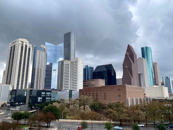 Downtown Houston's skyline, with skyscrapers, on a rainy, cloudy day.